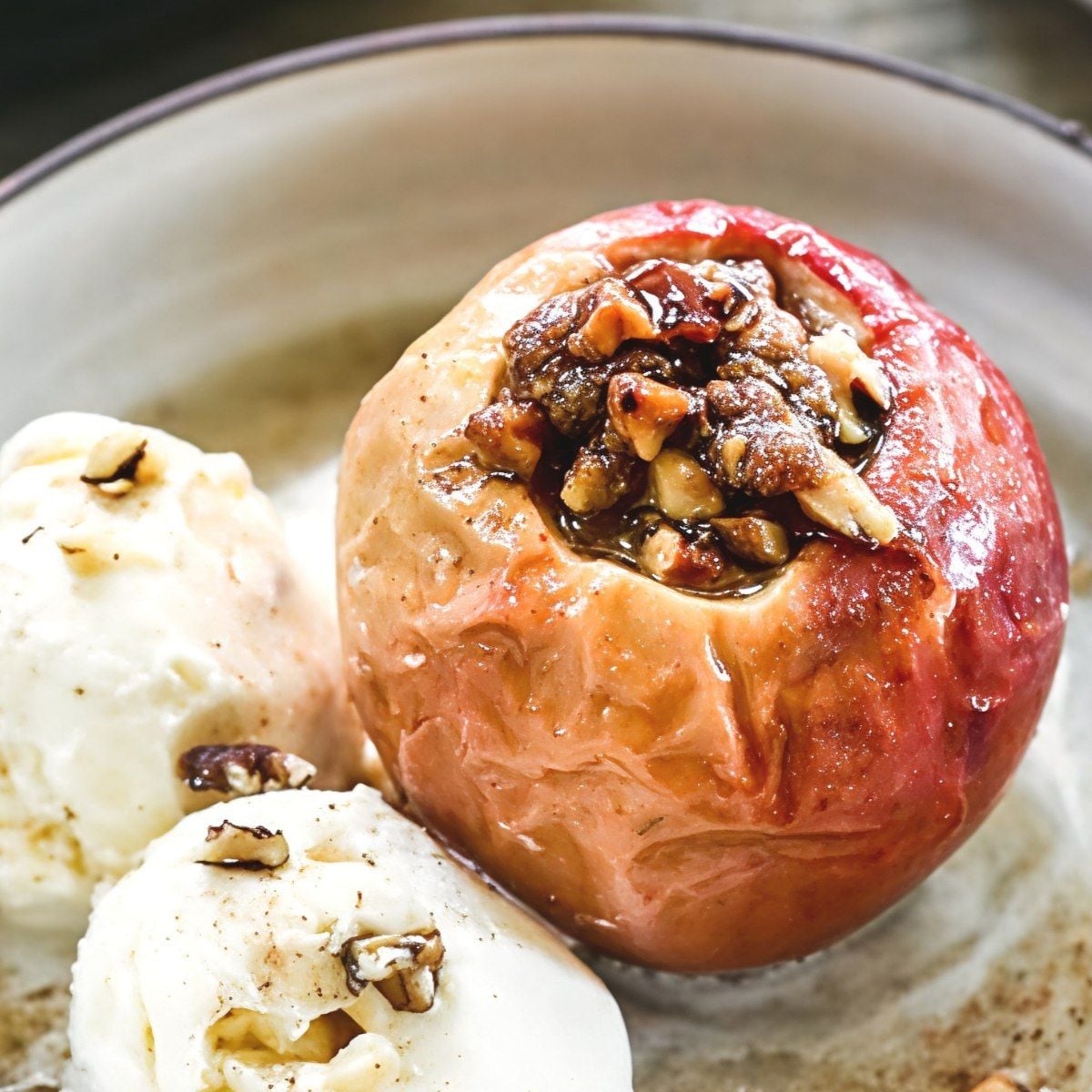 A warm baked apple stuffed with nuts and served with vanilla ice cream, perfect for gluten-free Thanksgiving desserts.