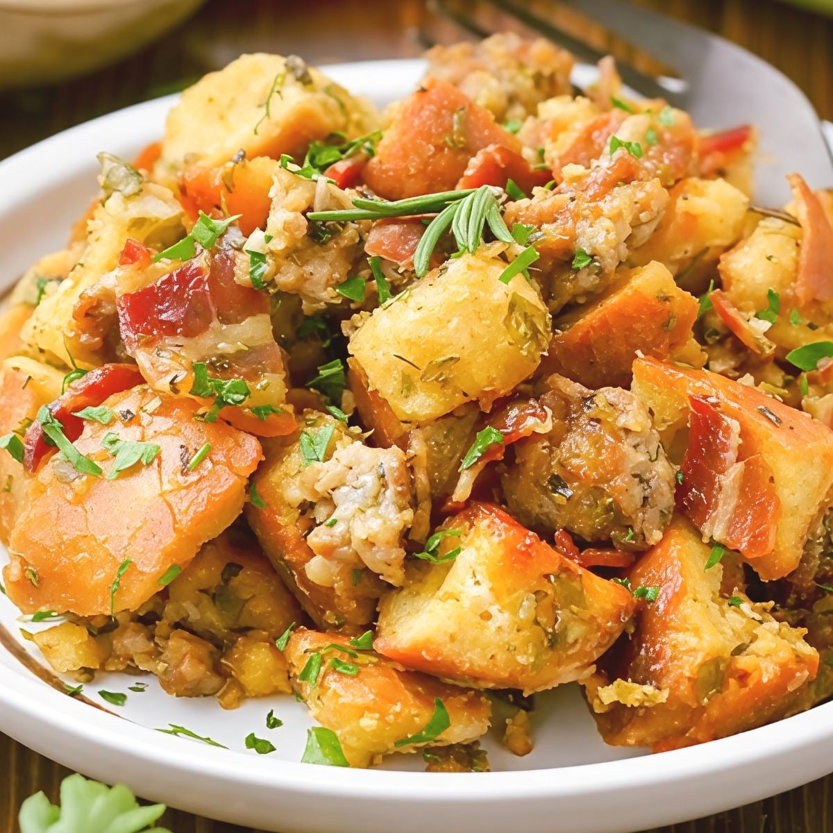 The best crockpot stuffing thanksgiving recipe featuring golden bread cubes, herbs, and fresh parsley garnish served in a shallow bowl.