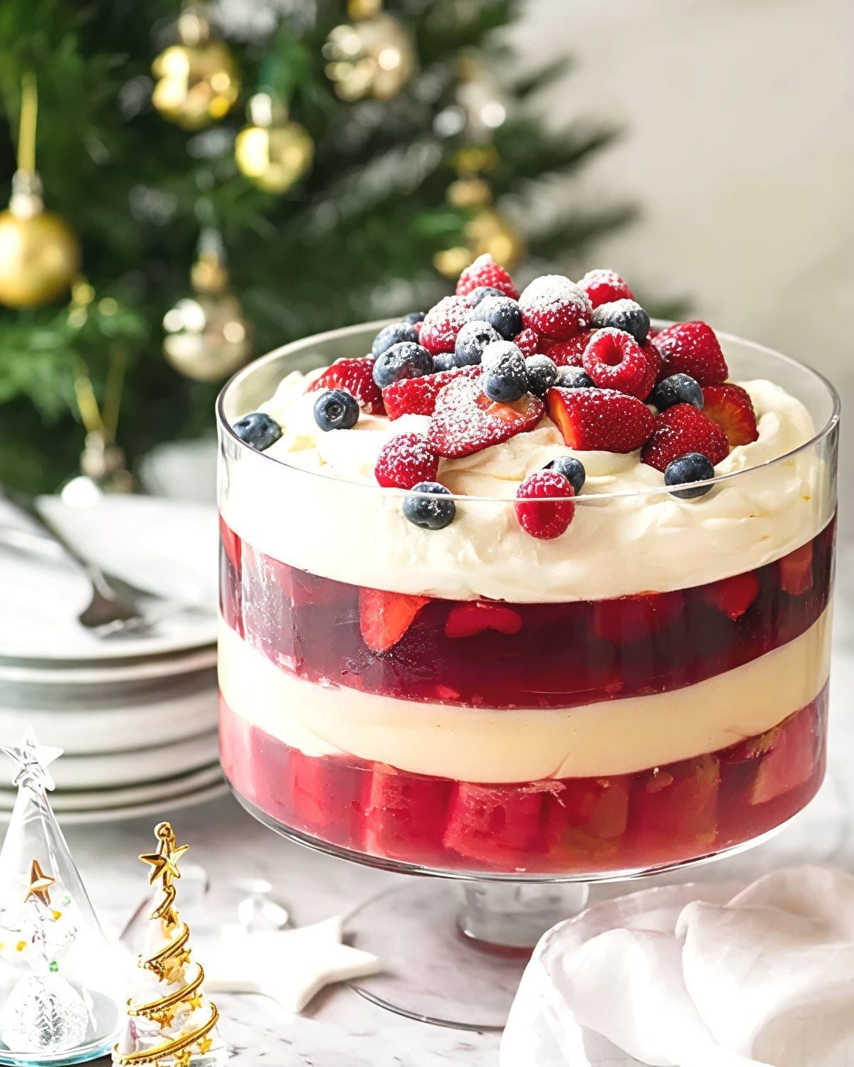 A classic British Christmas trifle layered with jelly, custard, and whipped cream, topped with fresh berries in a clear glass bowl as a festive European Christmas dessert.