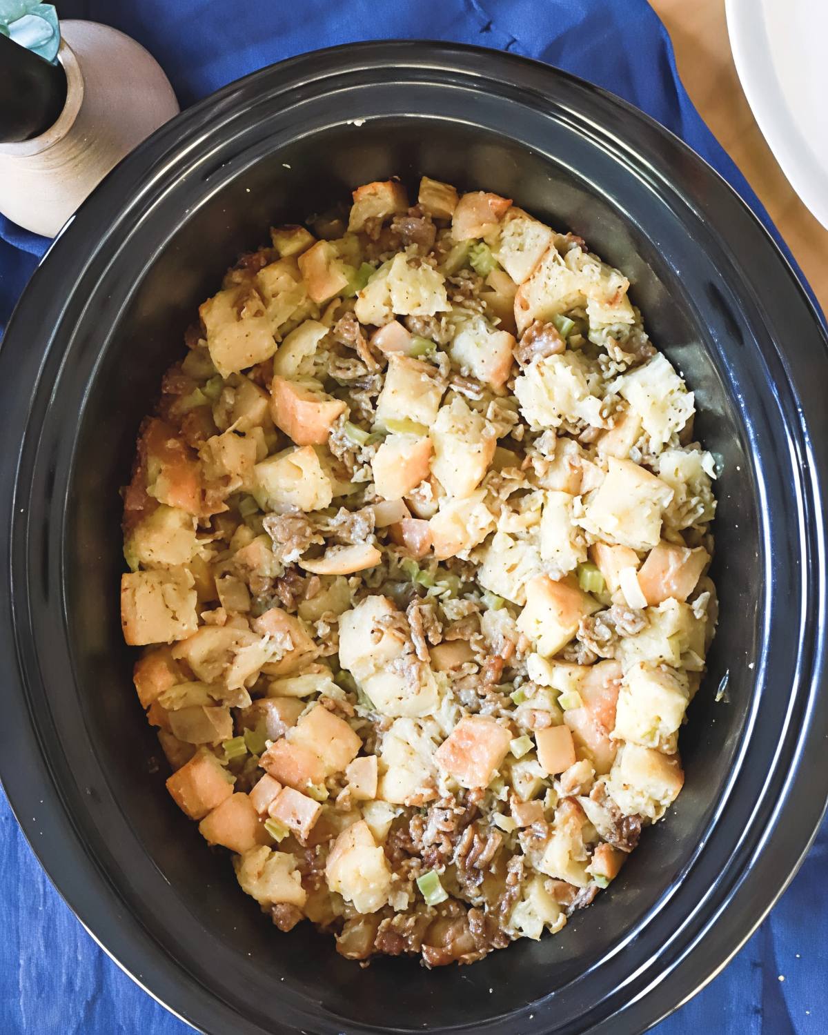 Hearty crockpot stuffing thanksgiving recipe with savory sausage, crisp apples, and toasted bread cubes cooked in a slow cooker insert.