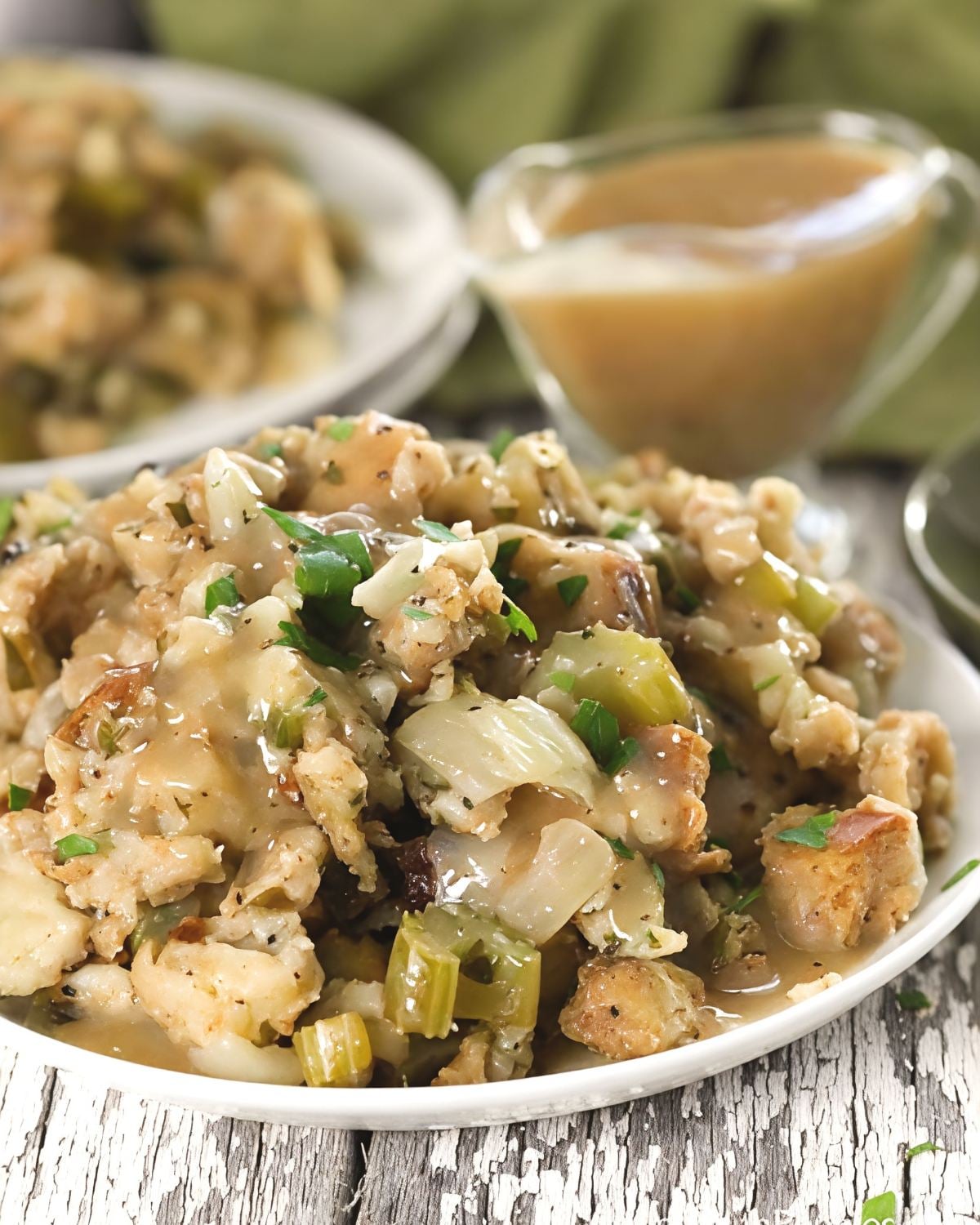 Plate of savory crockpot stuffing with celery and herbs drizzled with warm gravy, perfect for crockpot thanksgiving recipes.