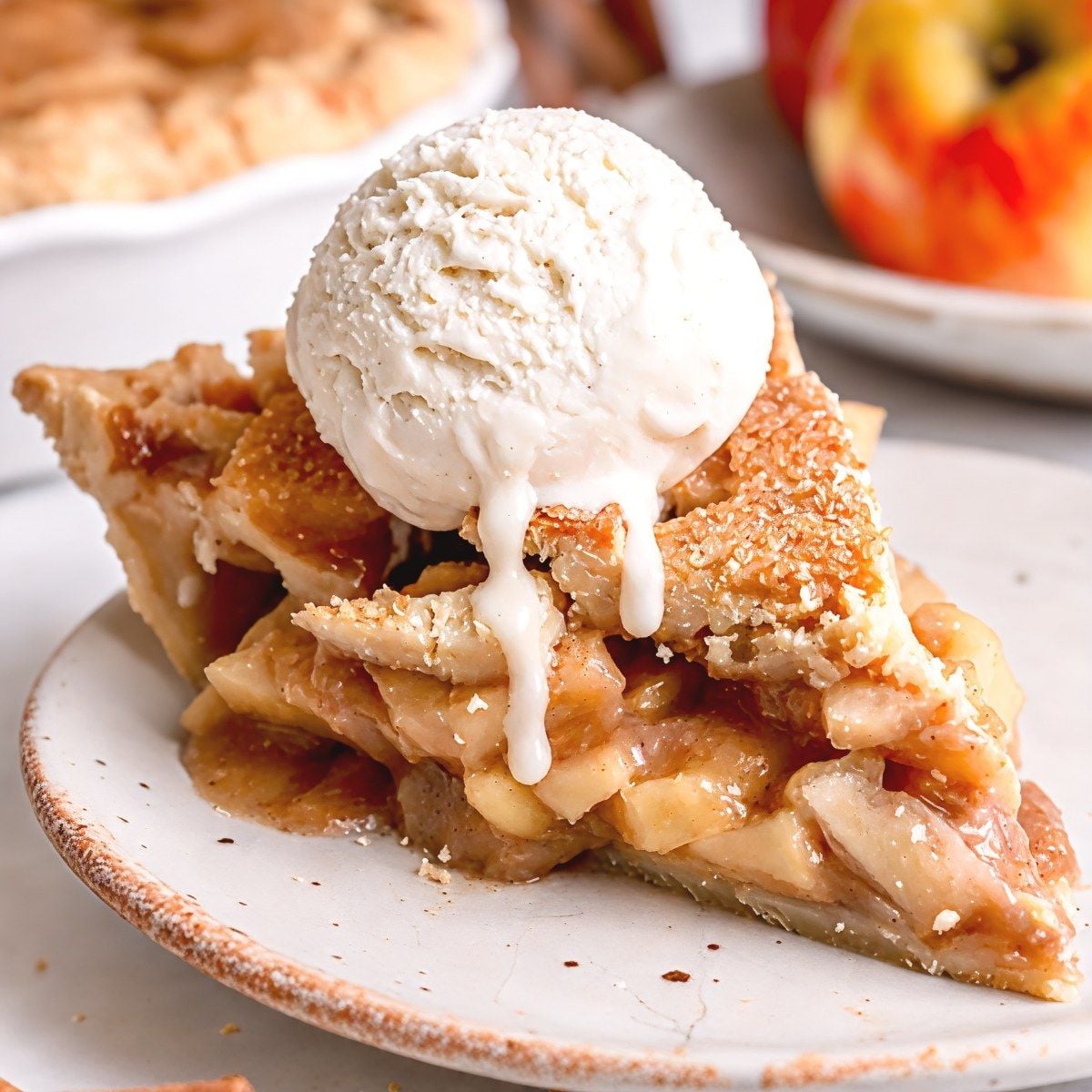 A slice of homemade gluten-free apple pie topped with vanilla ice cream, ideal for gluten-free Thanksgiving desserts.
