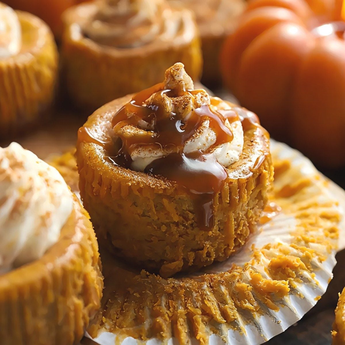 Mini gluten-free pumpkin cheesecake bites topped with whipped cream and caramel drizzle, perfect for gluten-free Thanksgiving desserts.