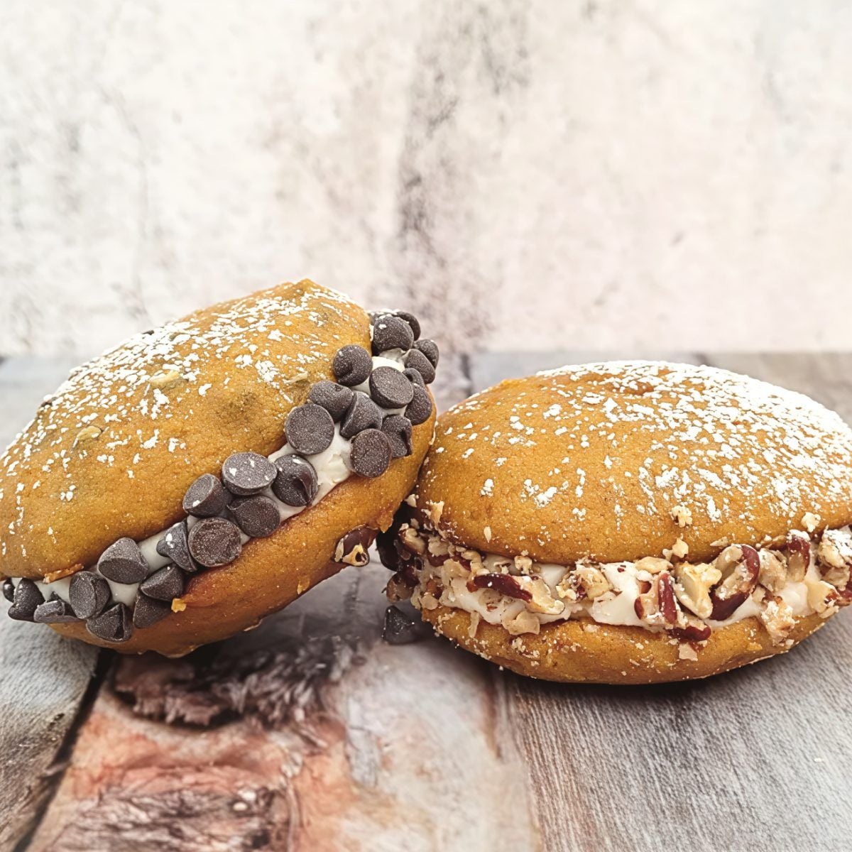 Gluten-free pumpkin whoopie pies filled with cream and rolled in chocolate chips and chopped pecans, perfect for gluten-free Thanksgiving desserts.