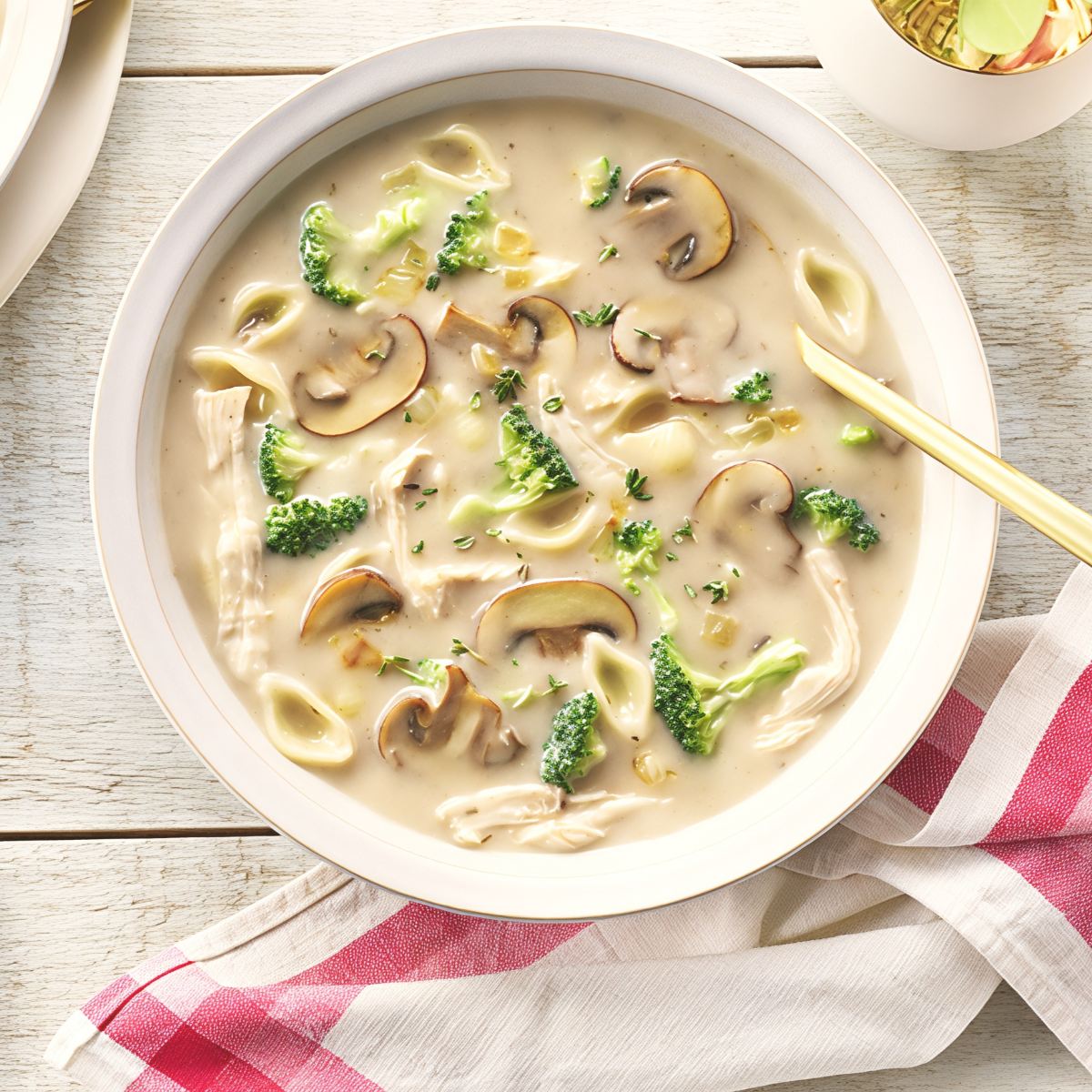 Creamy leftover turkey mushroom noodle soup with sliced mushrooms, shredded turkey, and broccoli in a bowl.