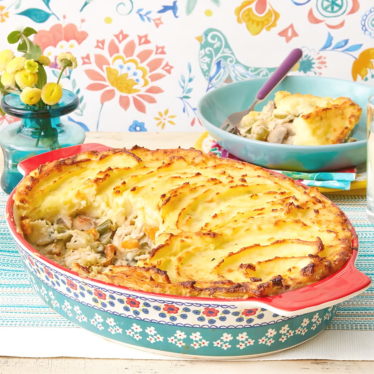 Freshly baked leftover turkey shepherd's pie topped with golden mashed potatoes in a ceramic baking dish, ideal for easy leftover turkey recipes.