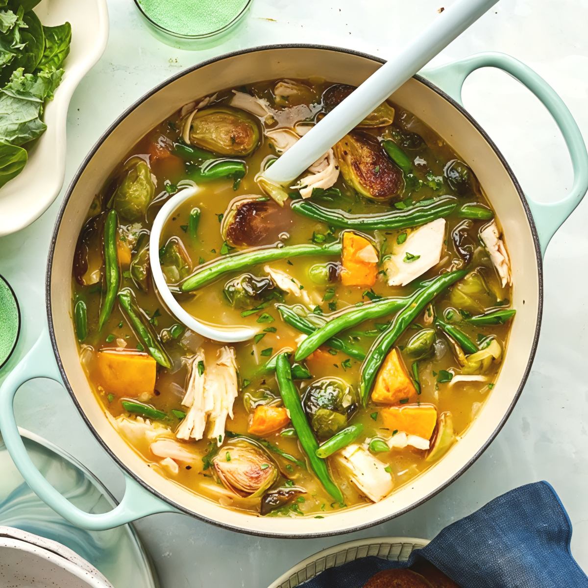 Hearty leftover turkey stew filled with tender shredded turkey, green beans, roasted Brussels sprouts, and sweet potatoes in a pot.