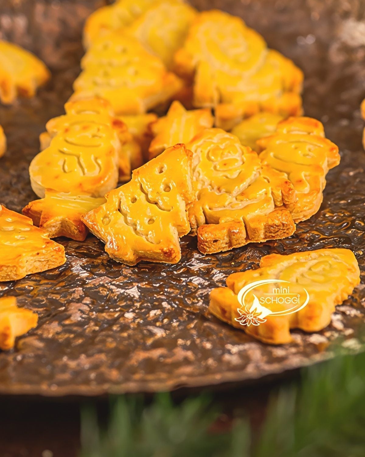 Golden-baked Swiss Mailänderli butter cookies cut into holiday shapes like Christmas trees and stars, featured as a classic European Christmas dessert.