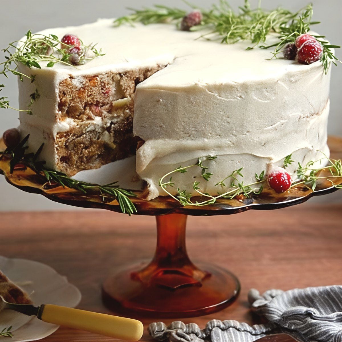Elegant frosted Thanksgiving layer cake garnished with a sprig of fresh rosemary and vibrant flowers on the sides.