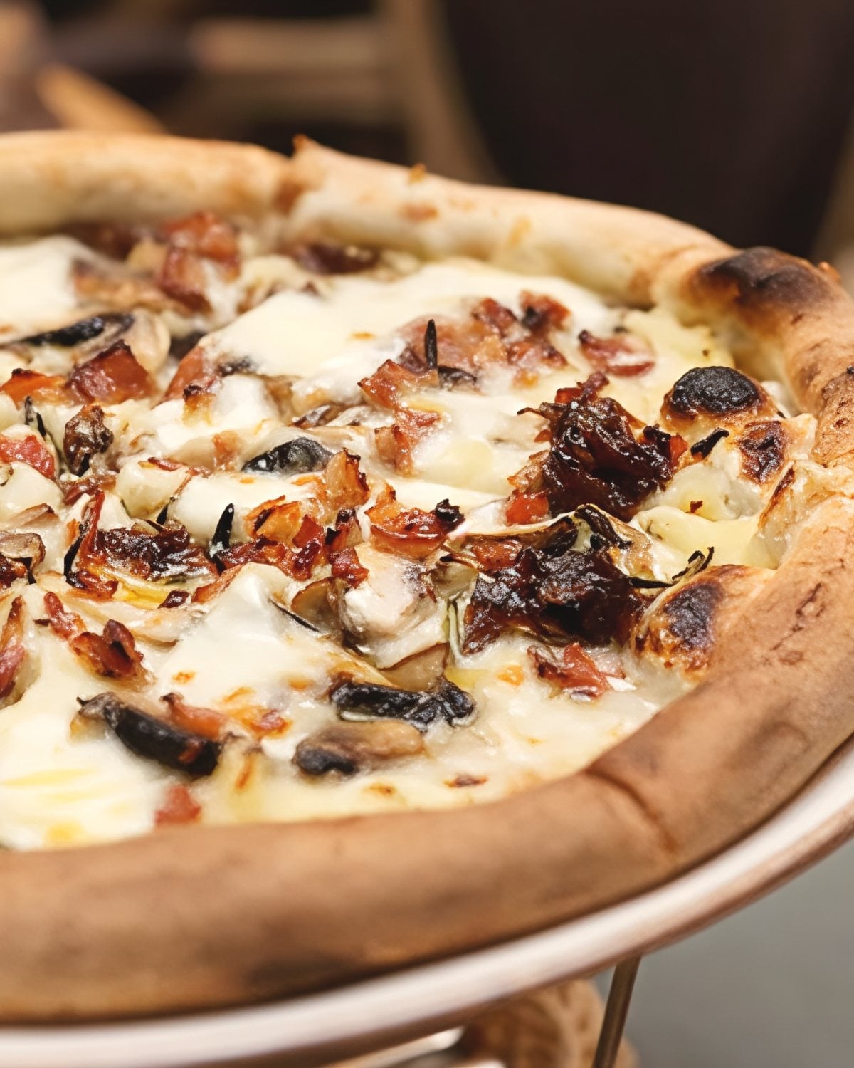 A freshly baked vegetarian Thanksgiving leftover mashed potato pizza topped with melted cheese, caramelized onions, and mushrooms on a thick golden crust