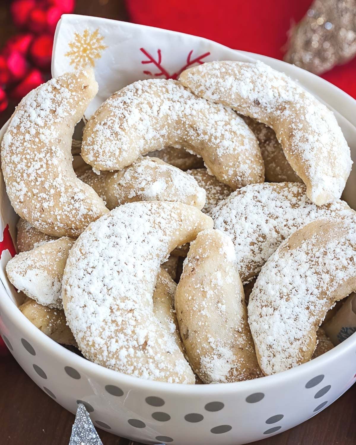 A decorative bowl filled with powdery, dusted crescent-shaped Vanillekipferl cookies served as a classic European Christmas dessert.